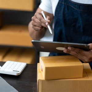 Freelance businessman checking and verifying shipping information Package boxes to prepare for deliv